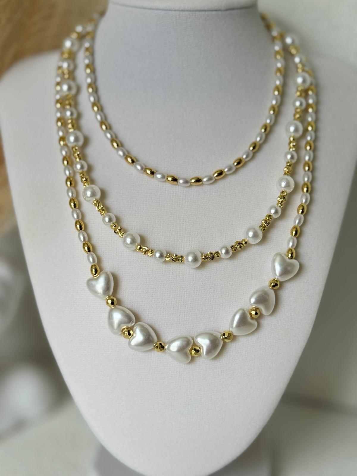 Three styles of synthetic pearl necklaces with 18K gold plated beads including oval pearl round pearl and heart pearl designs